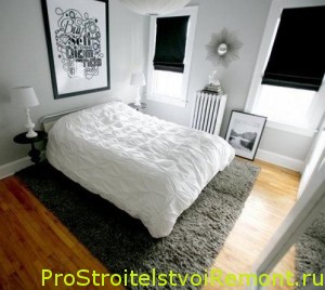 Современная спальная комната с ковром и двуспальной кроватью фото